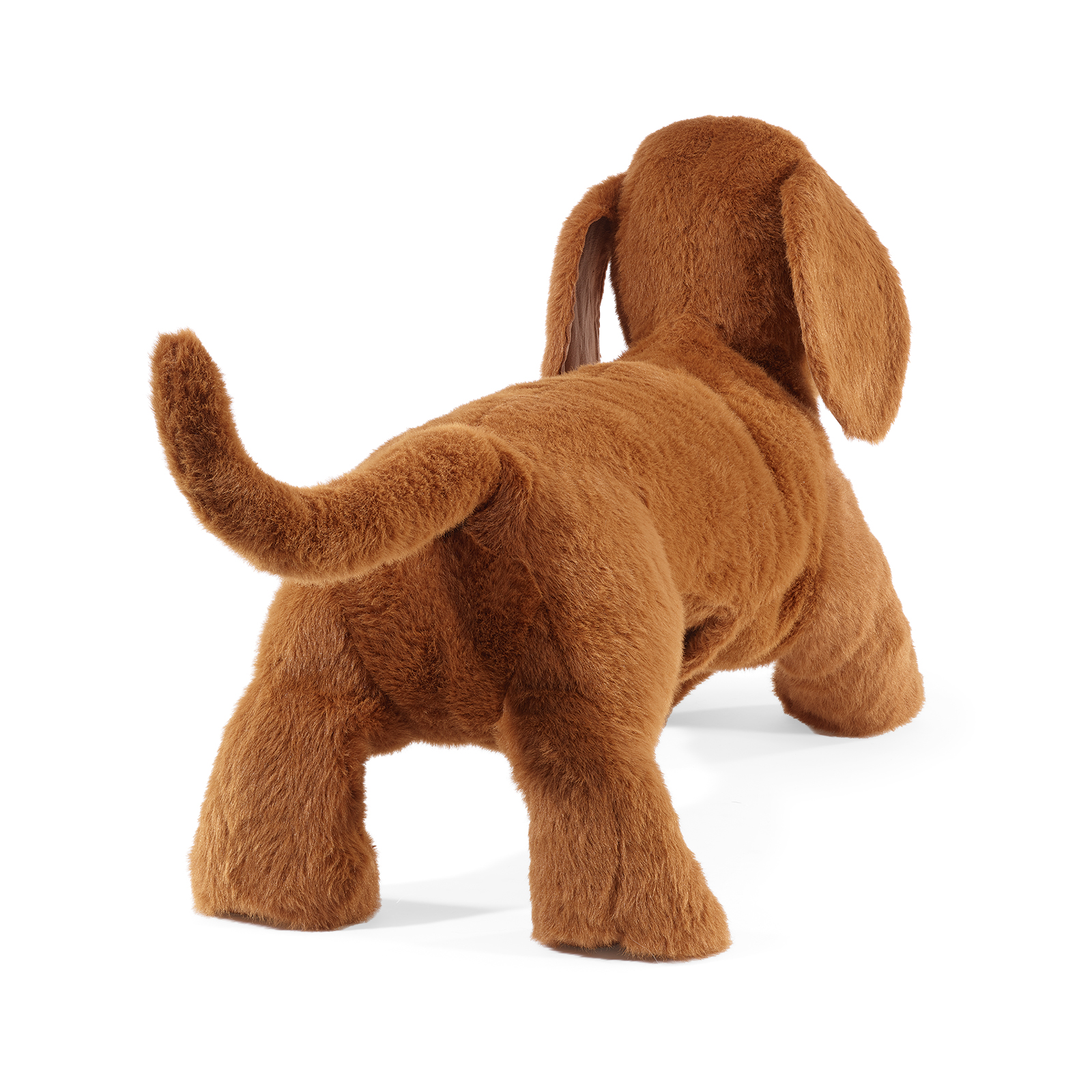 Folkmanis dachshund hand puppet seen from behind, its tail raised and one floppy ear visible to the side.