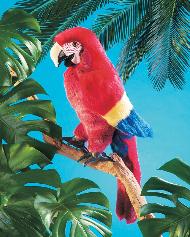 Folkmanis hand puppet scarlet macaw in vivid red with yellow-blue wings, perched on a branch against a turquoise-blue background with monstera leaves
