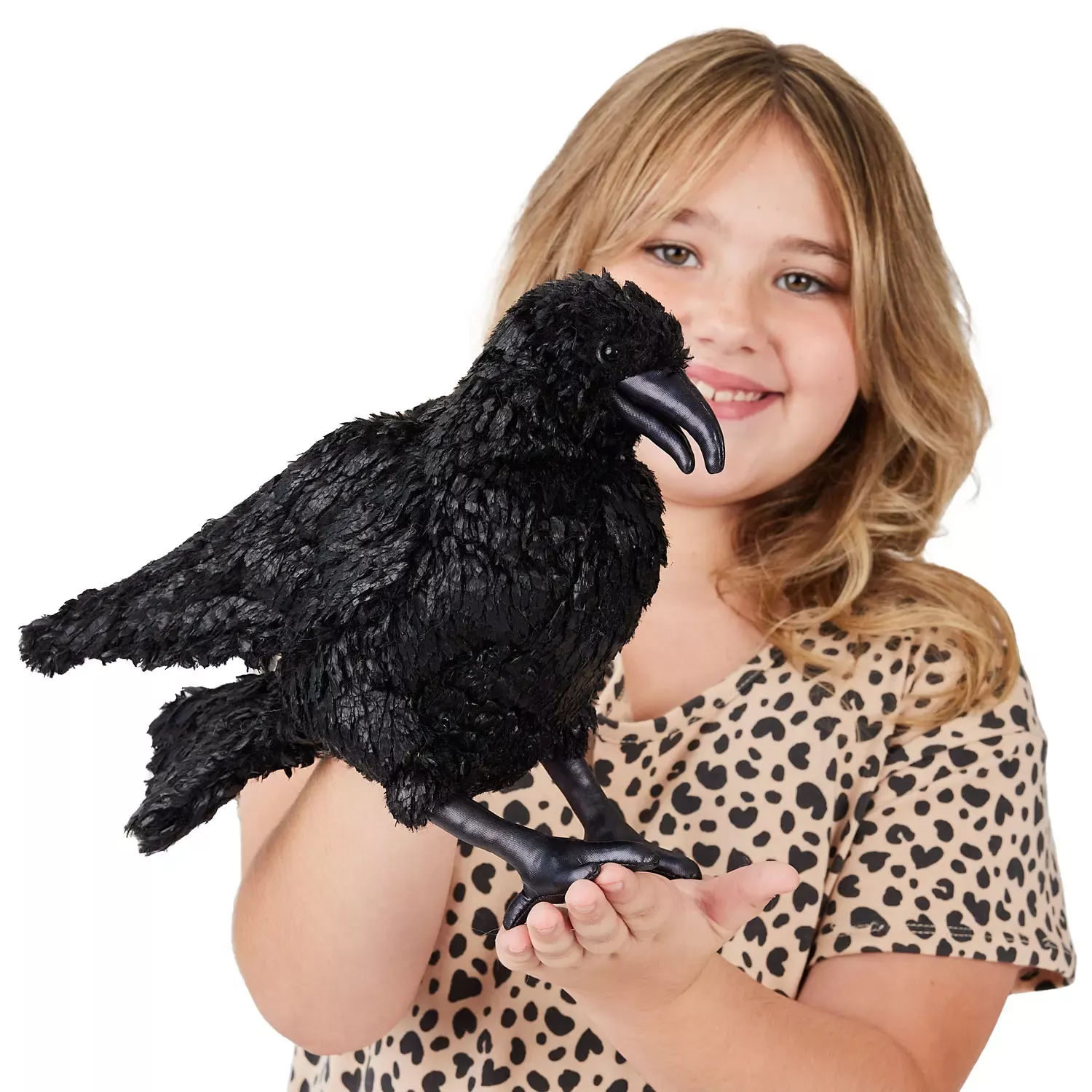Folkmanis hand puppet raven in deep black with detailed plumage, curved beak and claws, held on a girl's hand