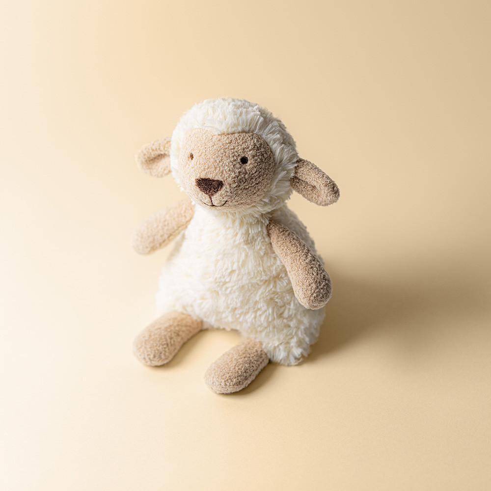 Jellycat plush toy lamb Lollie Lamb against a cream-coloured background, three-quarter view