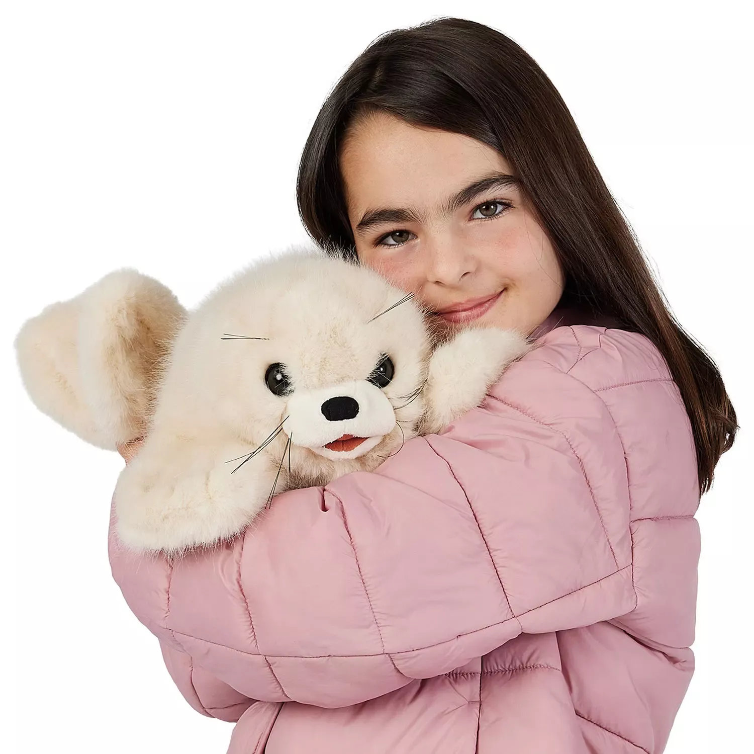 Girl in a pink quilted jacket hugging a Folkmanis harp seal pup hand puppet with cream fur and whiskers