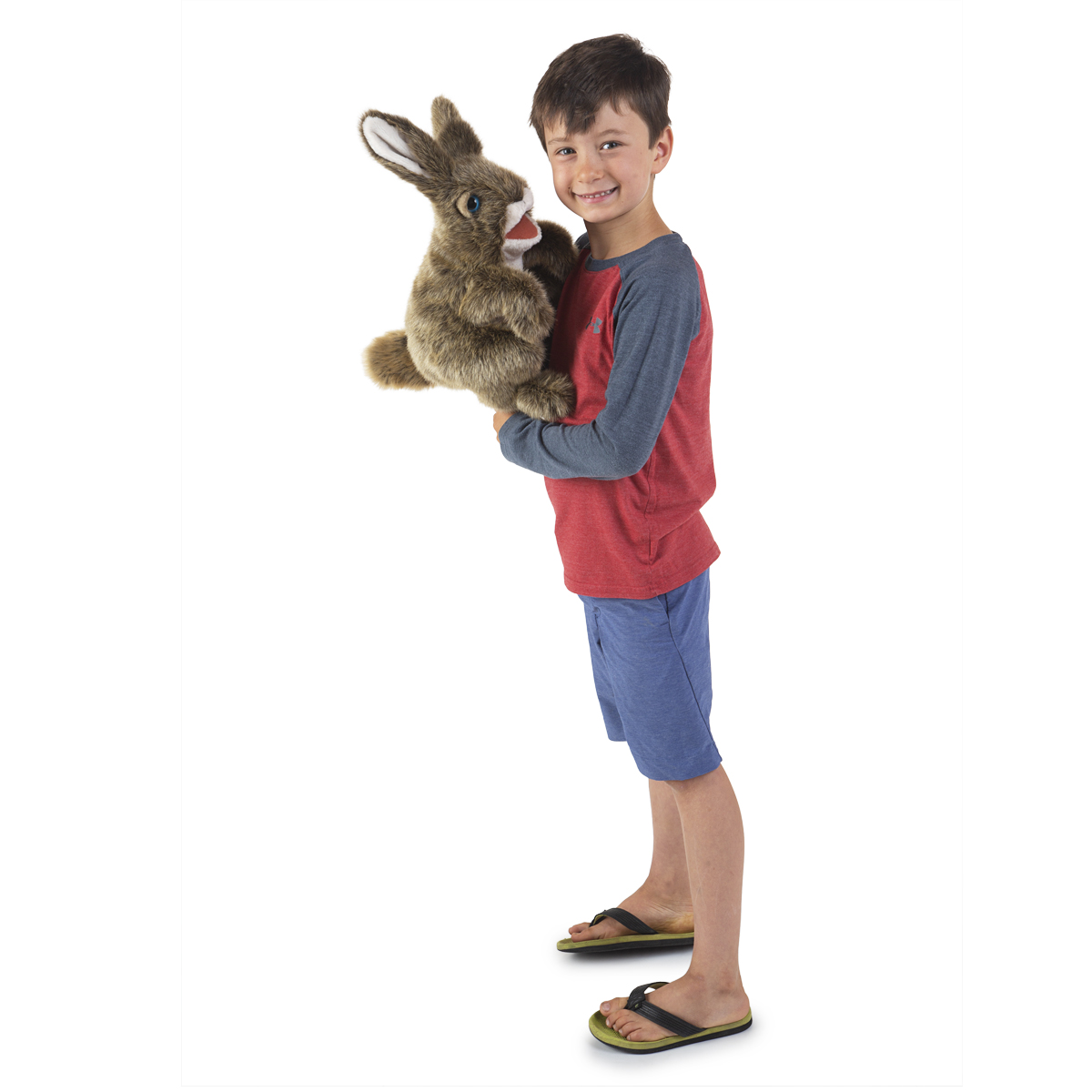 Boy holding a Folkmanis hand puppet hare with brown fur and movable mouth, side view