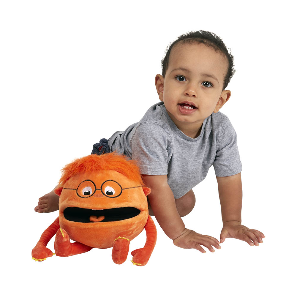 Toddler crawling towards the The Puppet Company orange baby monster hand puppet on the floor, usage example