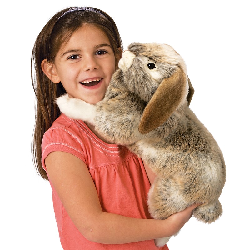 Girl holding the Folkmanis Holland Lop rabbit hand puppet with grey-brown mottled fur and drooping ears in her arms