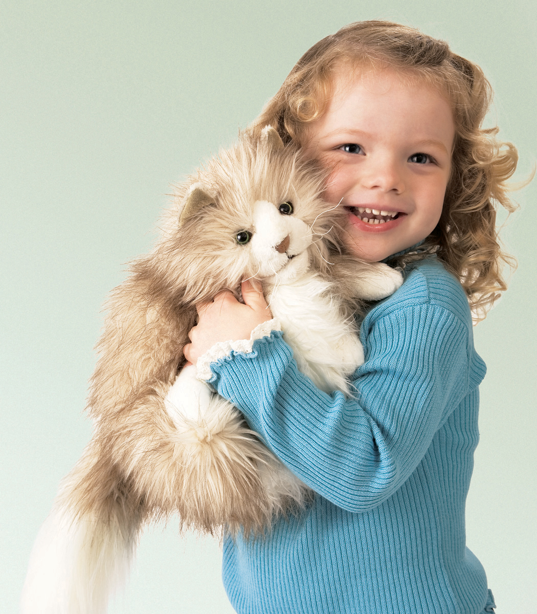 Smiling girl hugging the Folkmanis fluffy cat hand puppet with beige long fur and a white belly