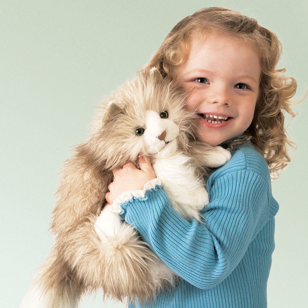 Smiling girl hugging the Folkmanis fluffy cat hand puppet with beige long fur and a white belly