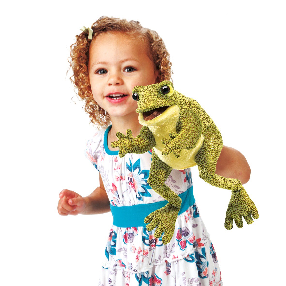 Smiling little girl holding up the Folkmanis Funny Frog hand puppet with its mouth open