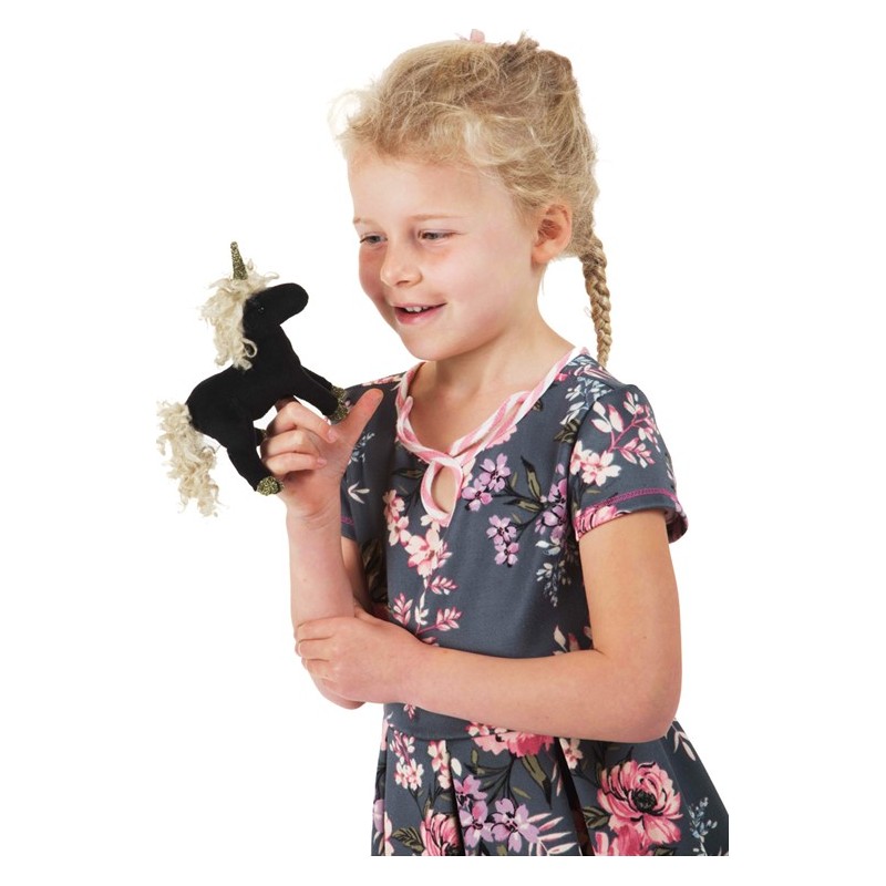 Girl holding a Folkmanis mini black unicorn finger puppet with a golden horn and curly mane on her finger