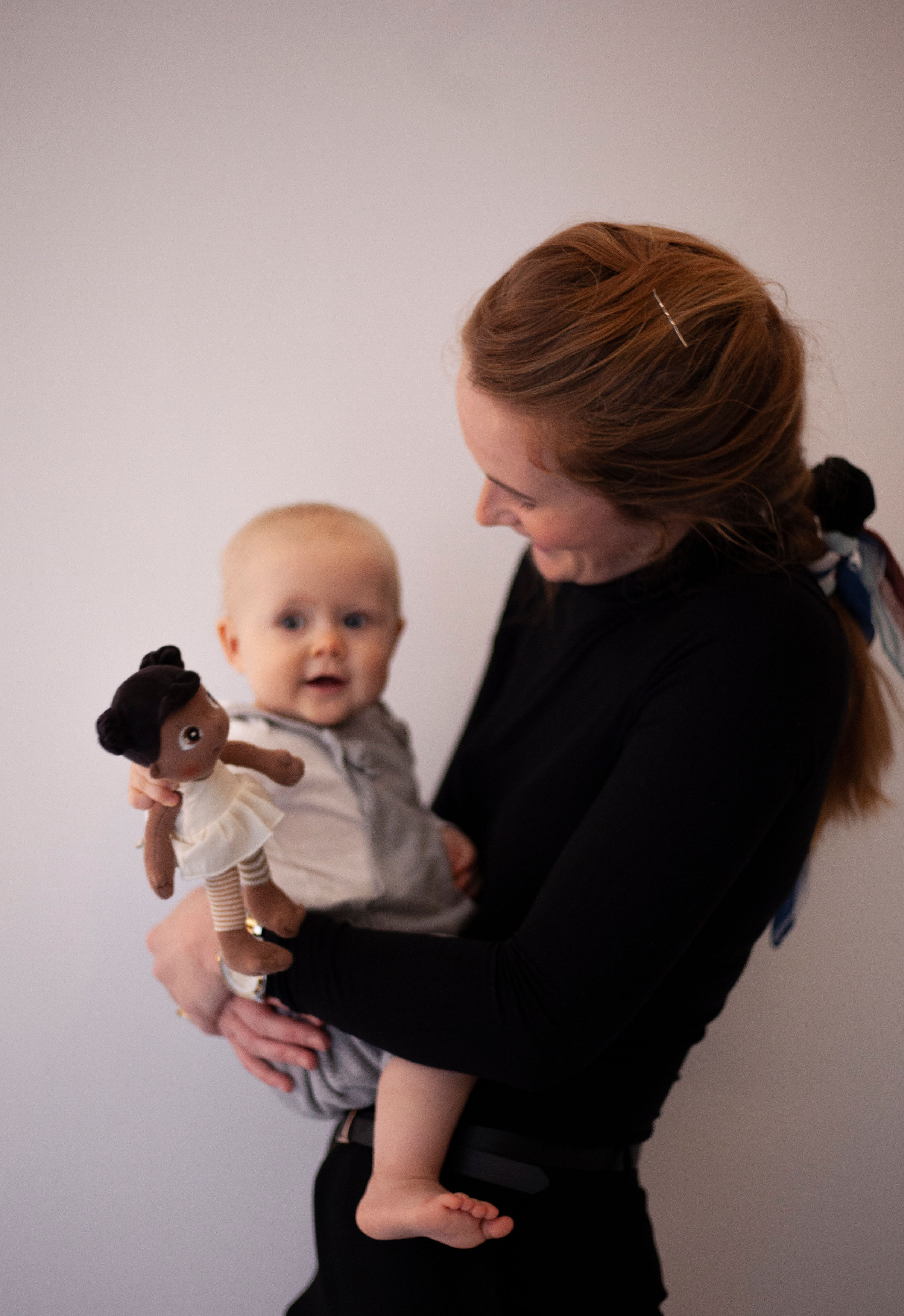 Woman showing a baby the Rubens EcoBuds mini doll Flora