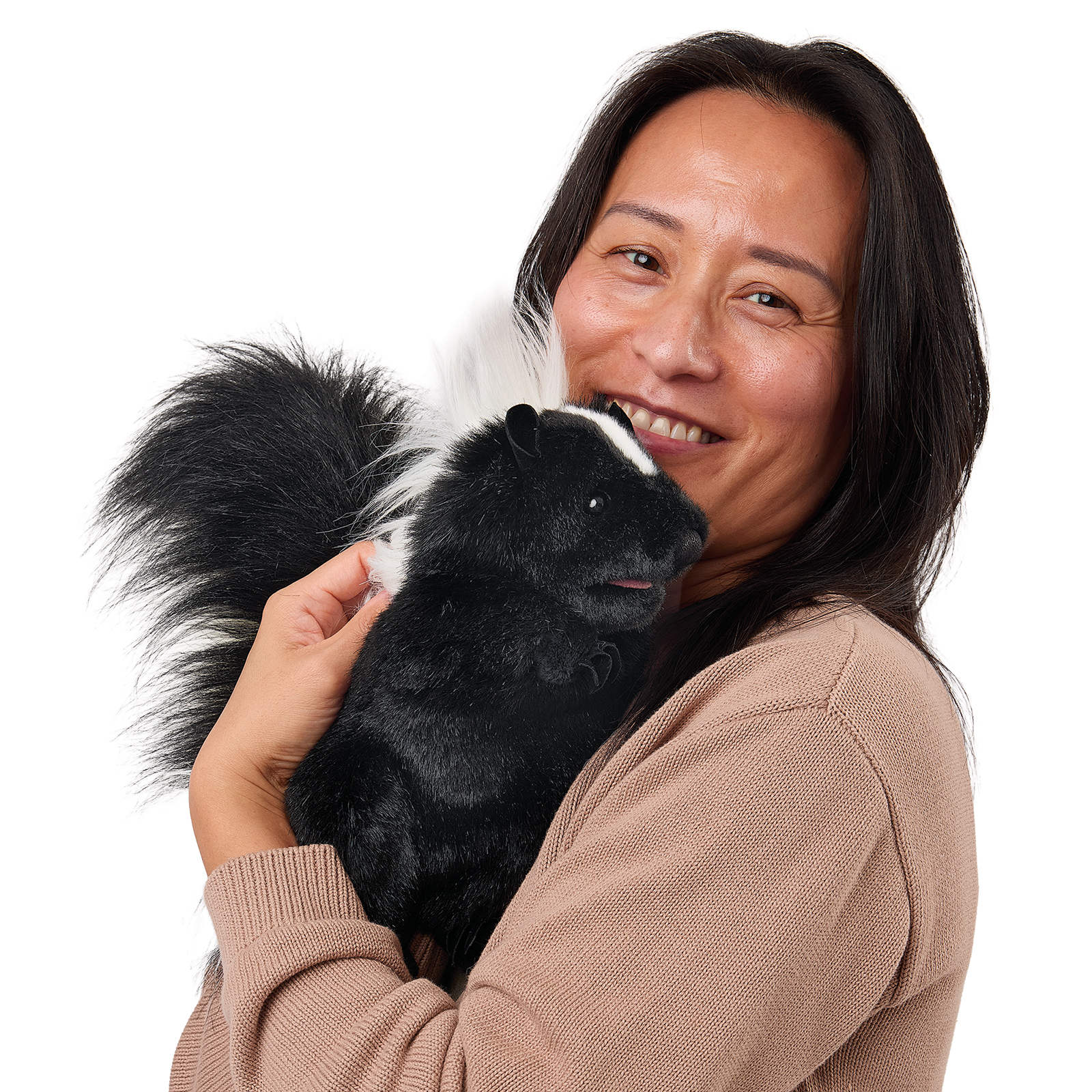 Folkmanis standing skunk hand puppet close to a woman's face, shown side-on with its head raised.