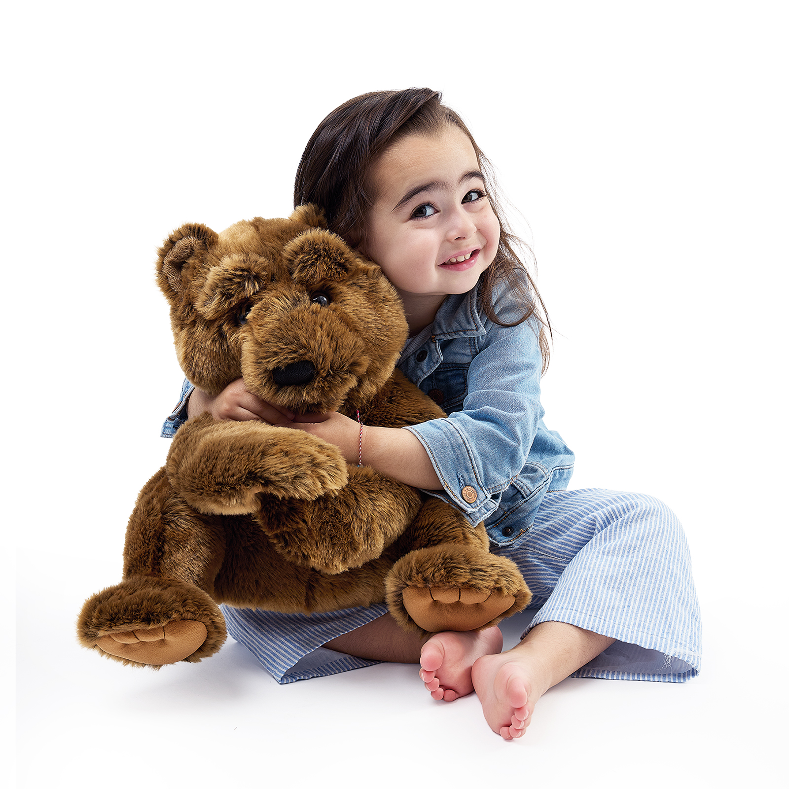 Folkmanis large bear hand puppet hugged by a girl, both front paws visible and its mouth closed.
