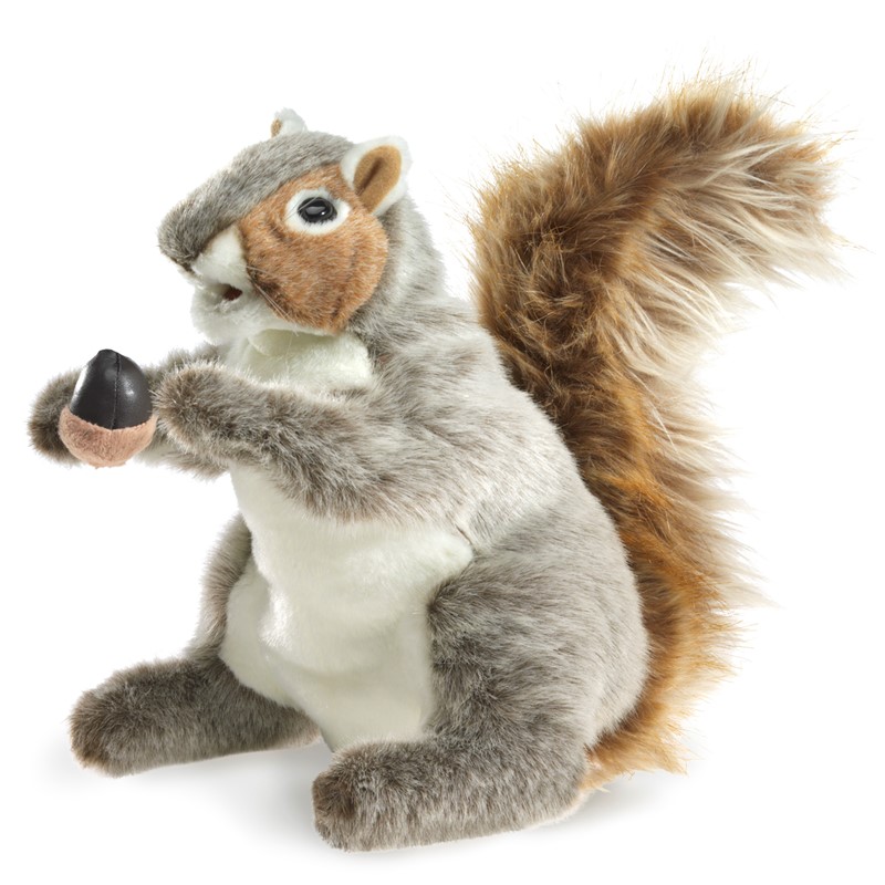 Folkmanis grey squirrel hand puppet with a reddish-brown tail, holding an acorn in its front paws, side view