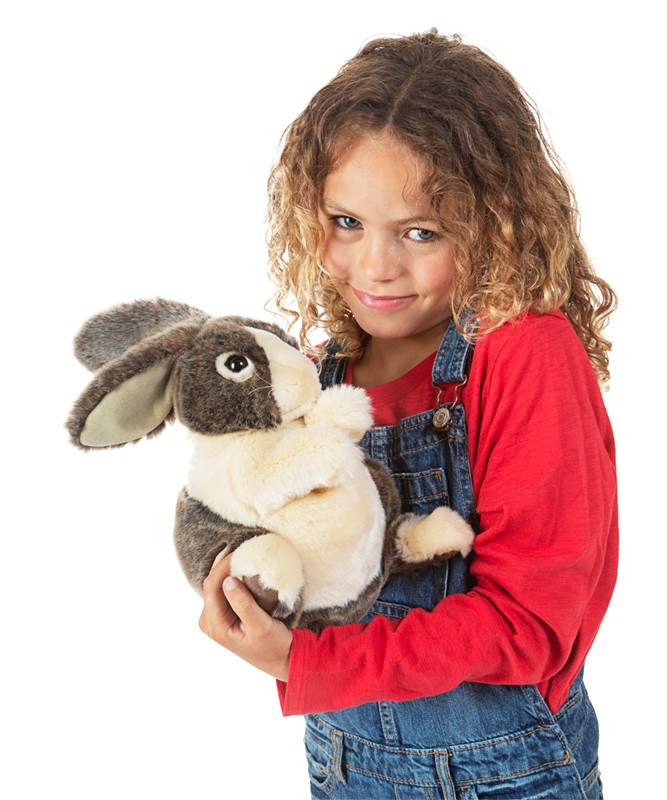 Girl holding a Folkmanis Dutch rabbit hand puppet with grey-and-white fur and floppy ears in both arms