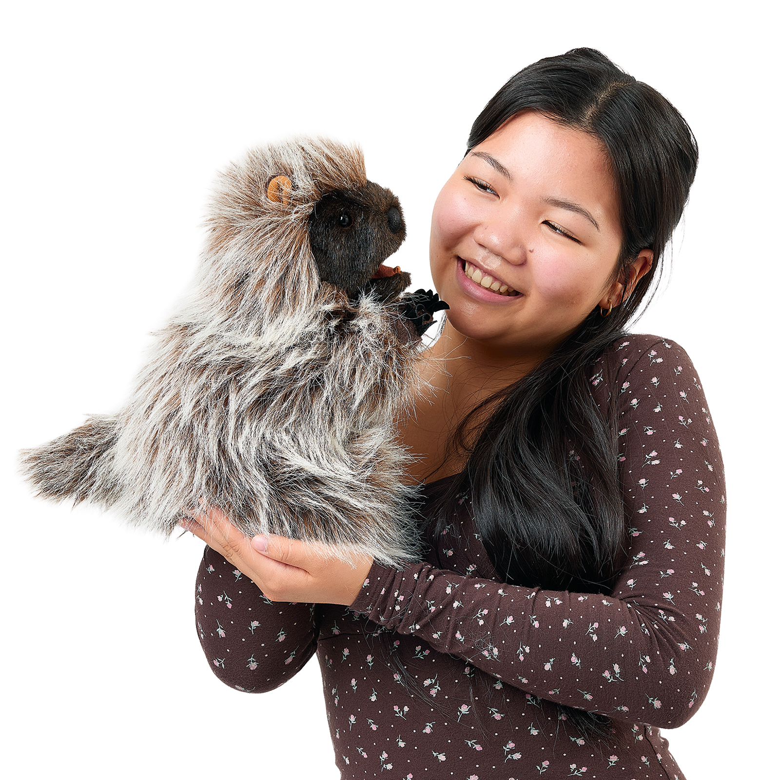 Folkmanis standing porcupine hand puppet close to a young woman's face, its mouth slightly open.