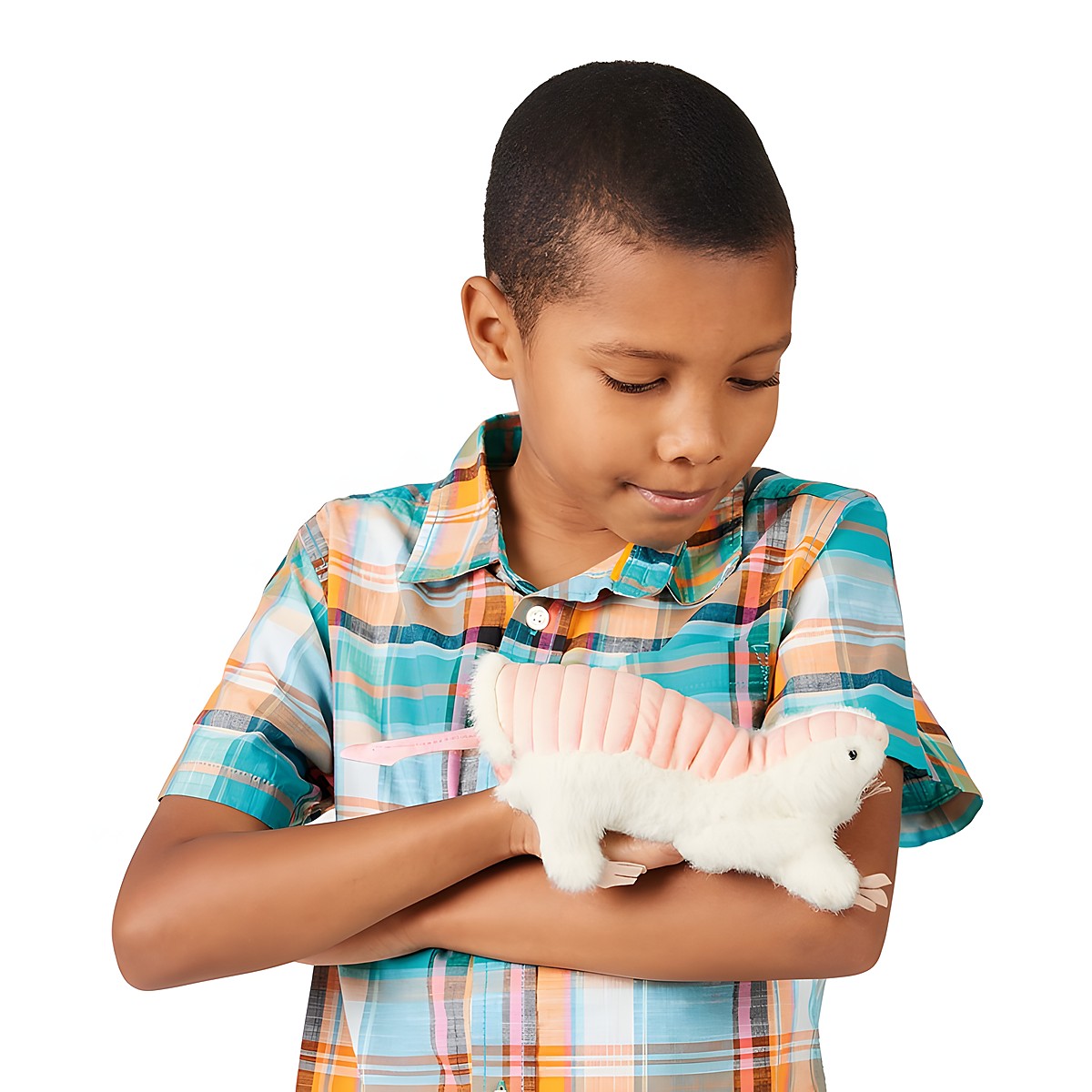 Boy holds a Folkmanis pink fairy armadillo hand puppet with white fur to his chest, smiling down at it