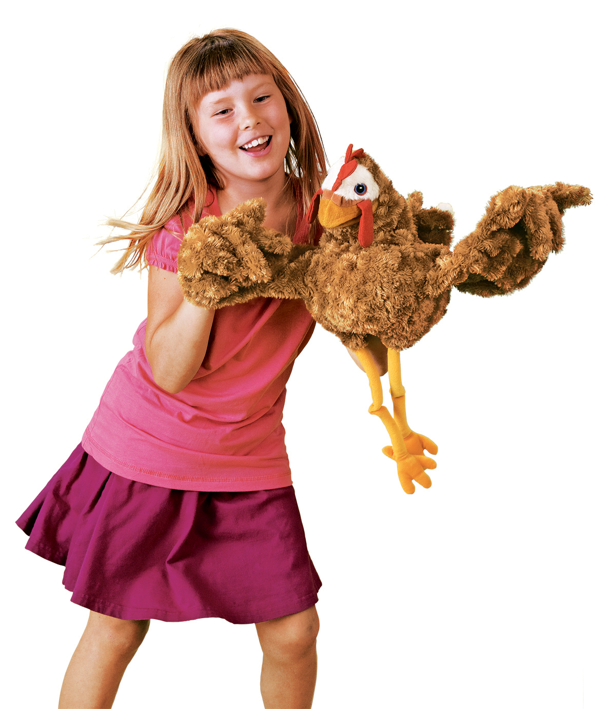 Smiling girl playing with the Folkmanis chicken hand puppet in brown plush with a red comb and yellow legs, full-body view