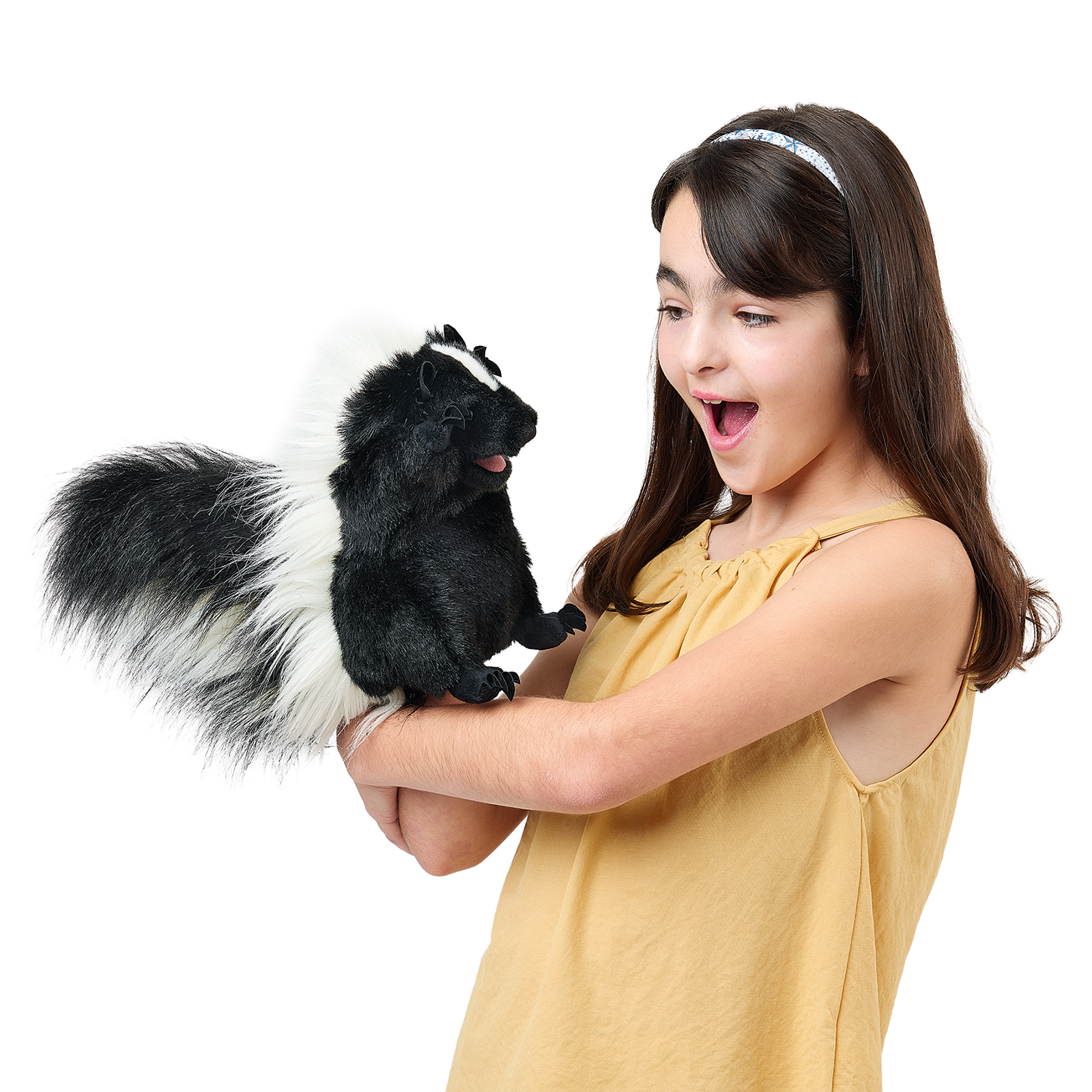 Folkmanis standing skunk hand puppet on a girl's arm, shown side-on with its mouth open.