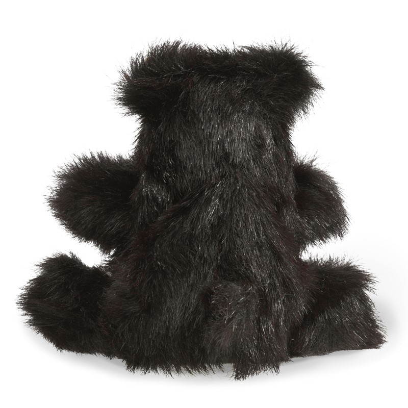 Folkmanis hand puppet small black bear with shaggy black fur, photographed from behind in a sitting position
