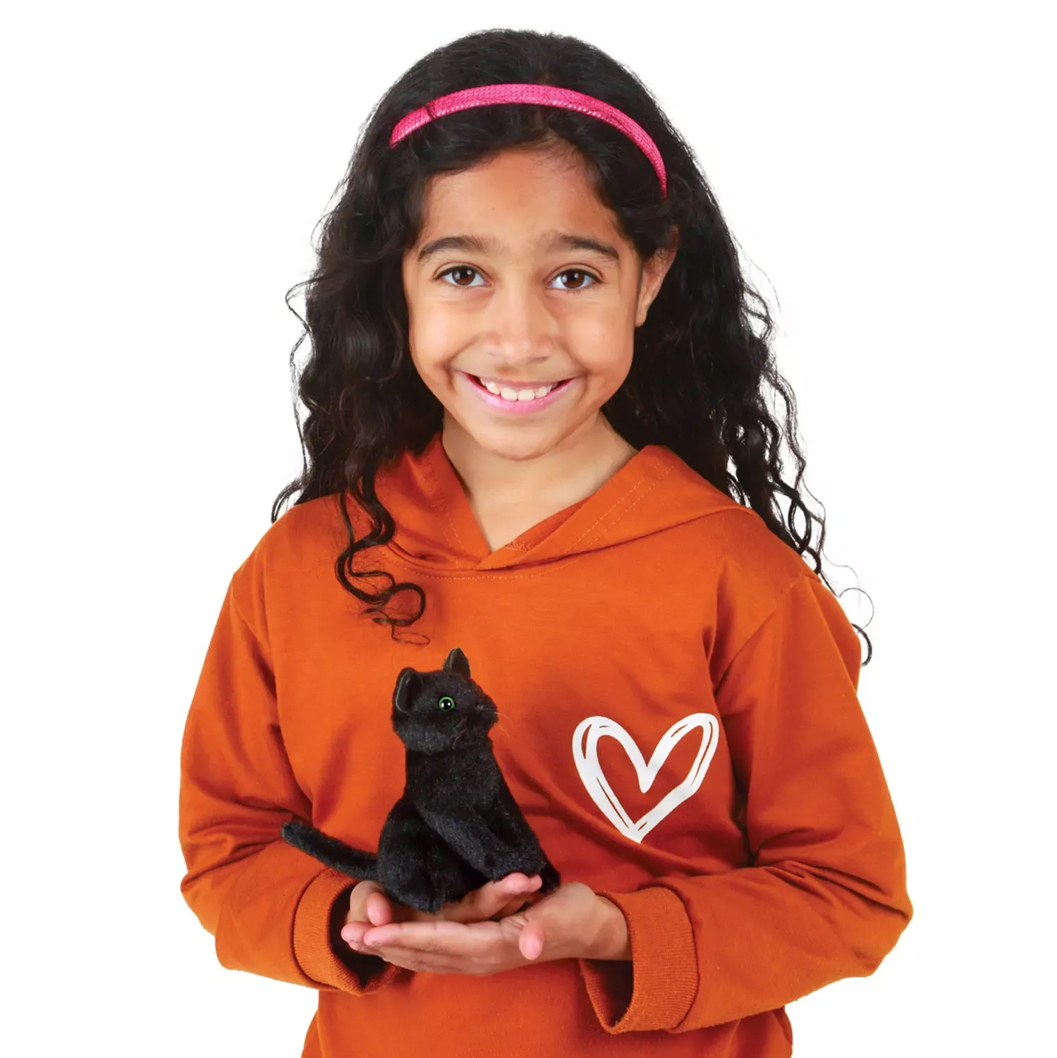 Girl holding a Folkmanis mini black cat finger puppet with green eyes in both hands, sitting pose