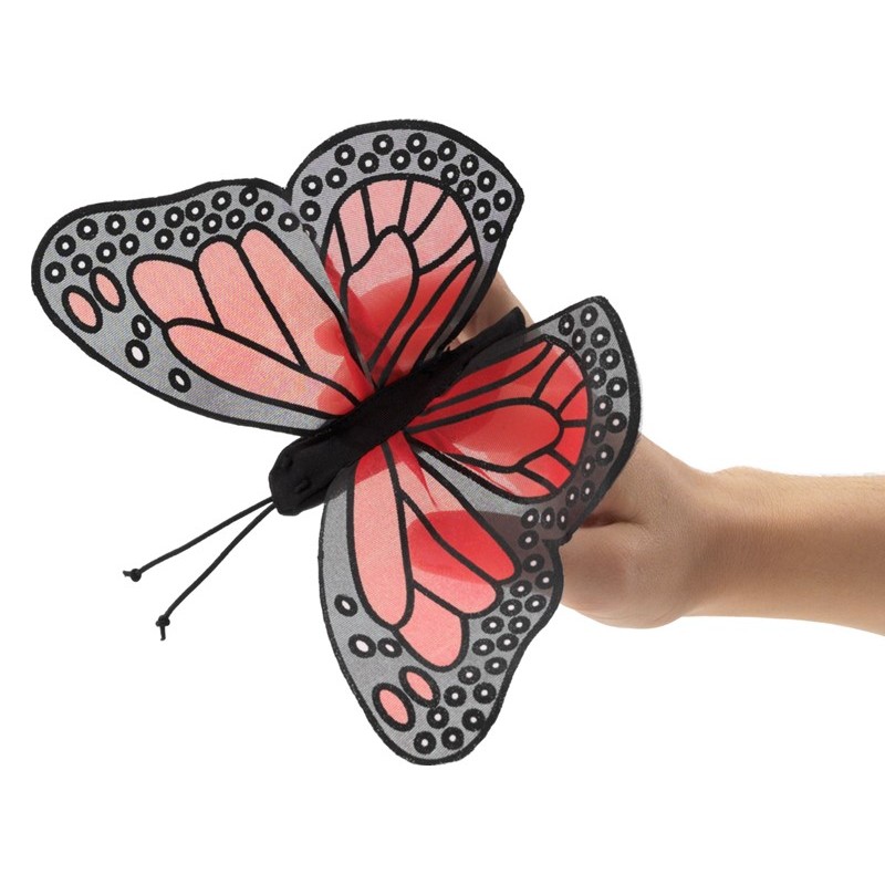 Folkmanis mini monarch butterfly finger puppet with red and black wings on an outstretched finger, side view