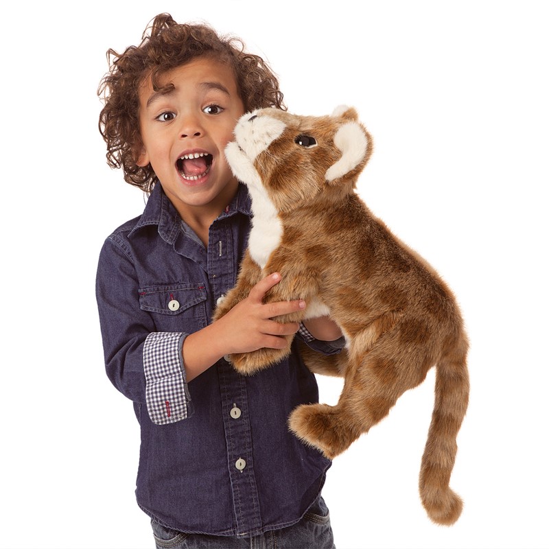 Child holding a Folkmanis African Lion Cub hand puppet made of brown plush with a light-coloured muzzle close to their face
