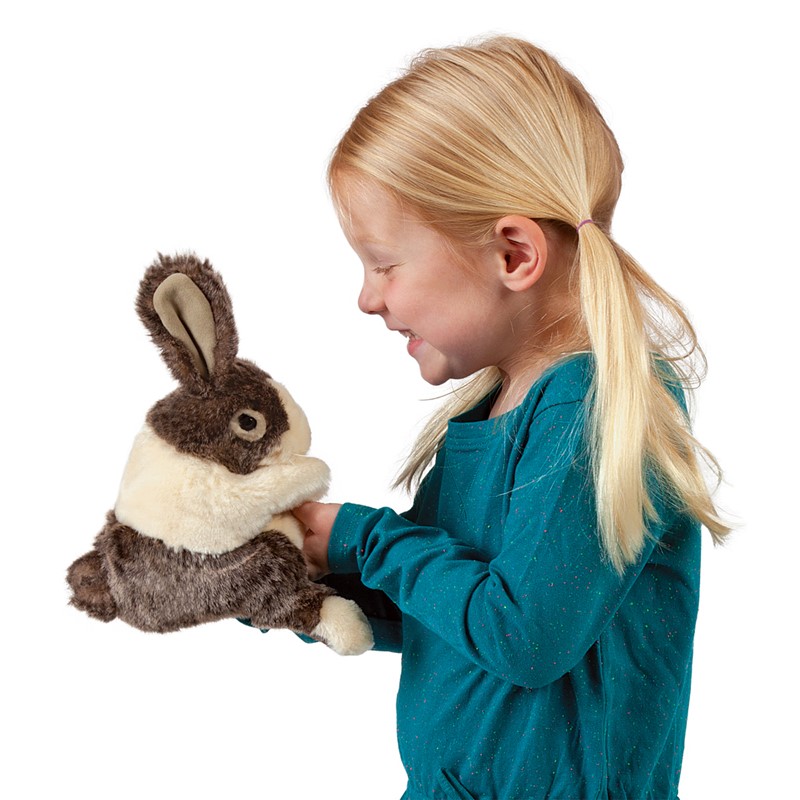 Girl operating the Folkmanis baby Dutch rabbit hand puppet with brown and cream fur from underneath with her hand