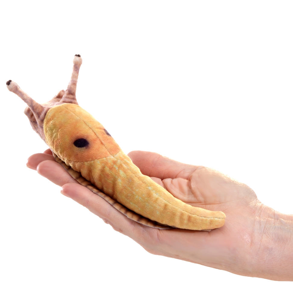 Folkmanis mini banana slug finger puppet in yellow-brown lying on an open palm, side view