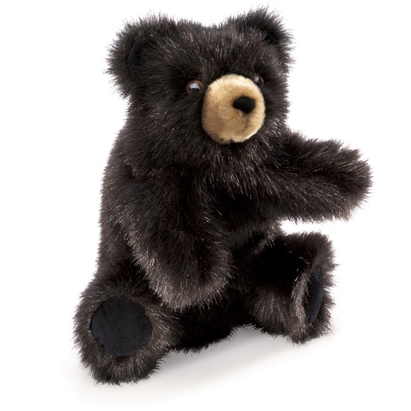 Folkmanis baby black bear hand puppet with black plush fur and beige muzzle area, sitting with one paw outstretched