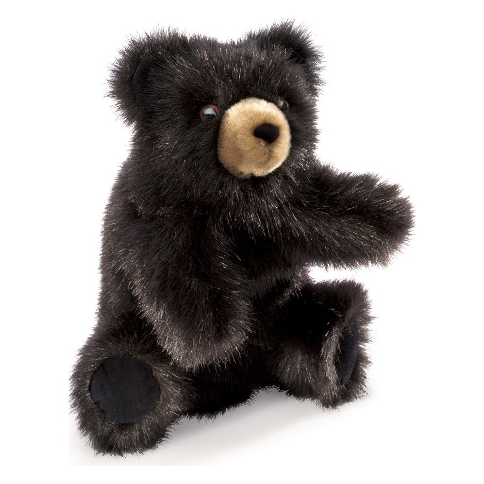 Folkmanis baby black bear hand puppet with black plush fur and beige muzzle area, sitting with one paw outstretched