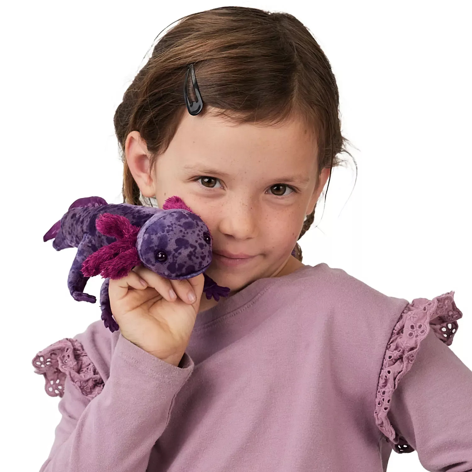 Girl holding a Folkmanis finger puppet of a Mexican axolotl in purple with pink-purple gills close to her face