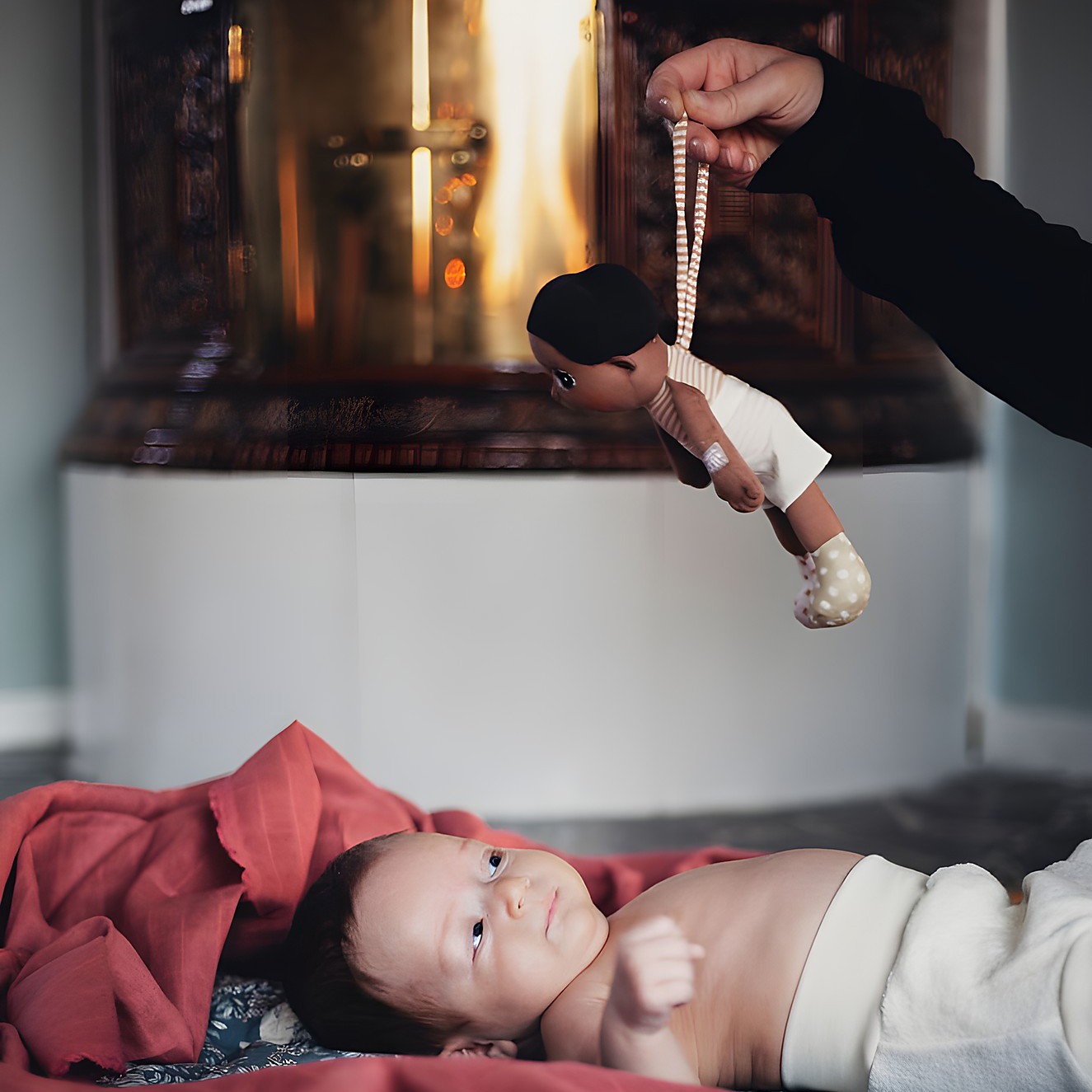 The Rubens EcoBuds mini doll Basil being handed to a lying baby