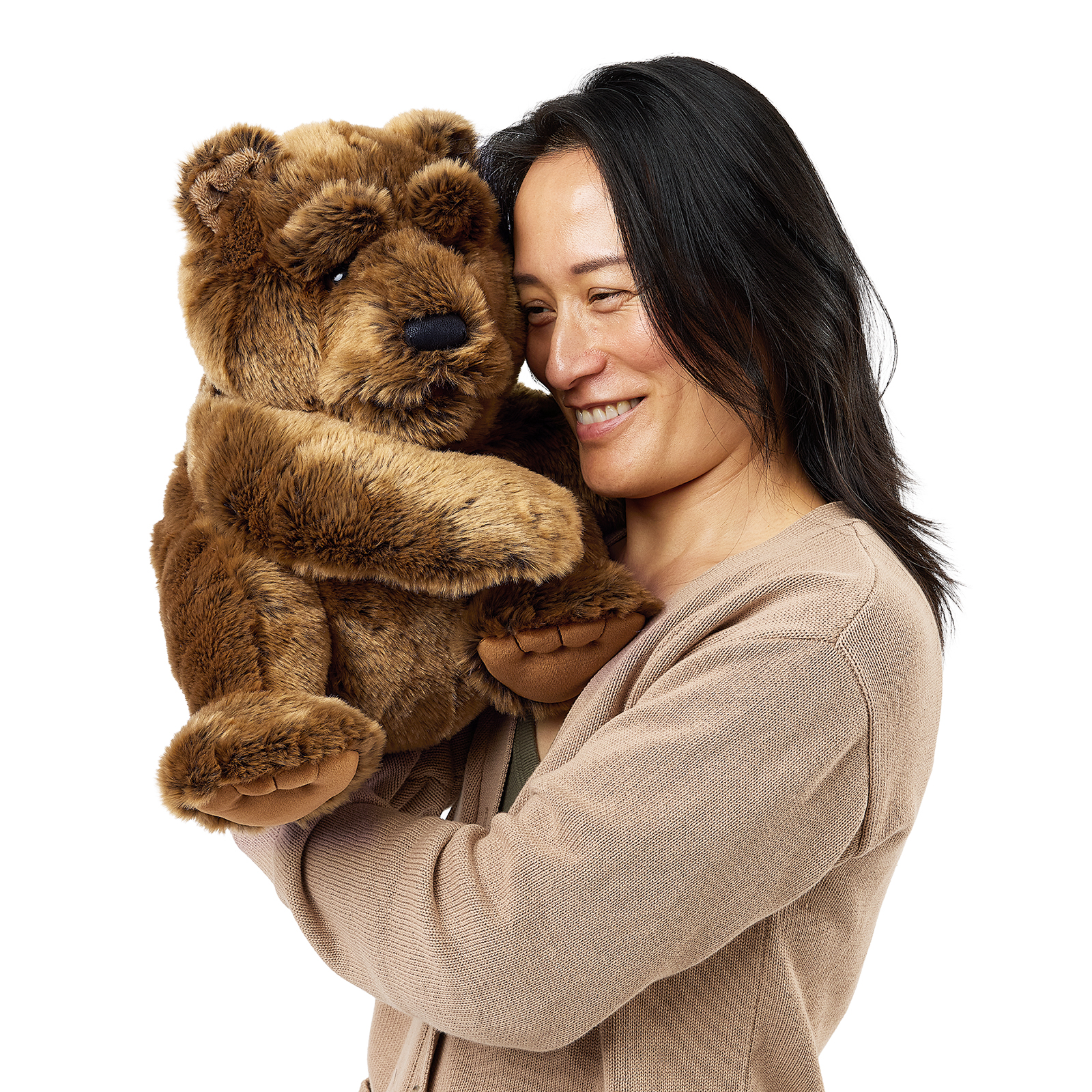 Folkmanis large bear hand puppet on a woman's hand, cheek to cheek with her, seen side-on with its mouth closed.