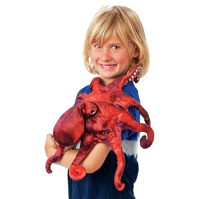 Child holding the Folkmanis red octopus hand puppet with eight tentacles and a realistic textured surface in their arms