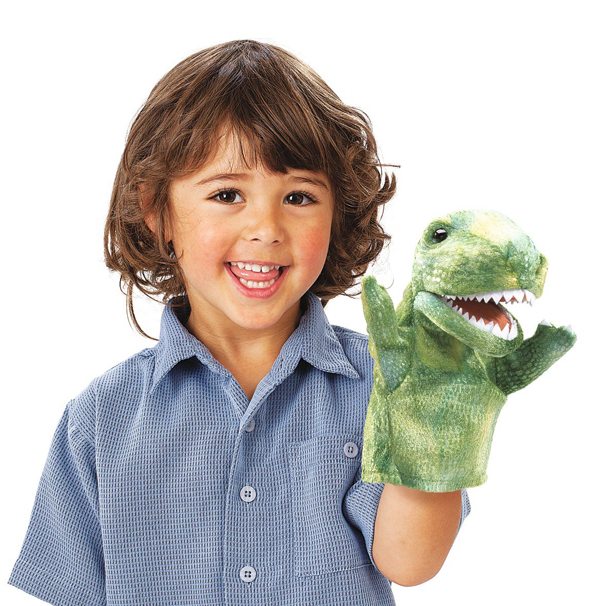 Child holding a green Folkmanis Little T-Rex hand puppet with open mouth and visible teeth up to the camera