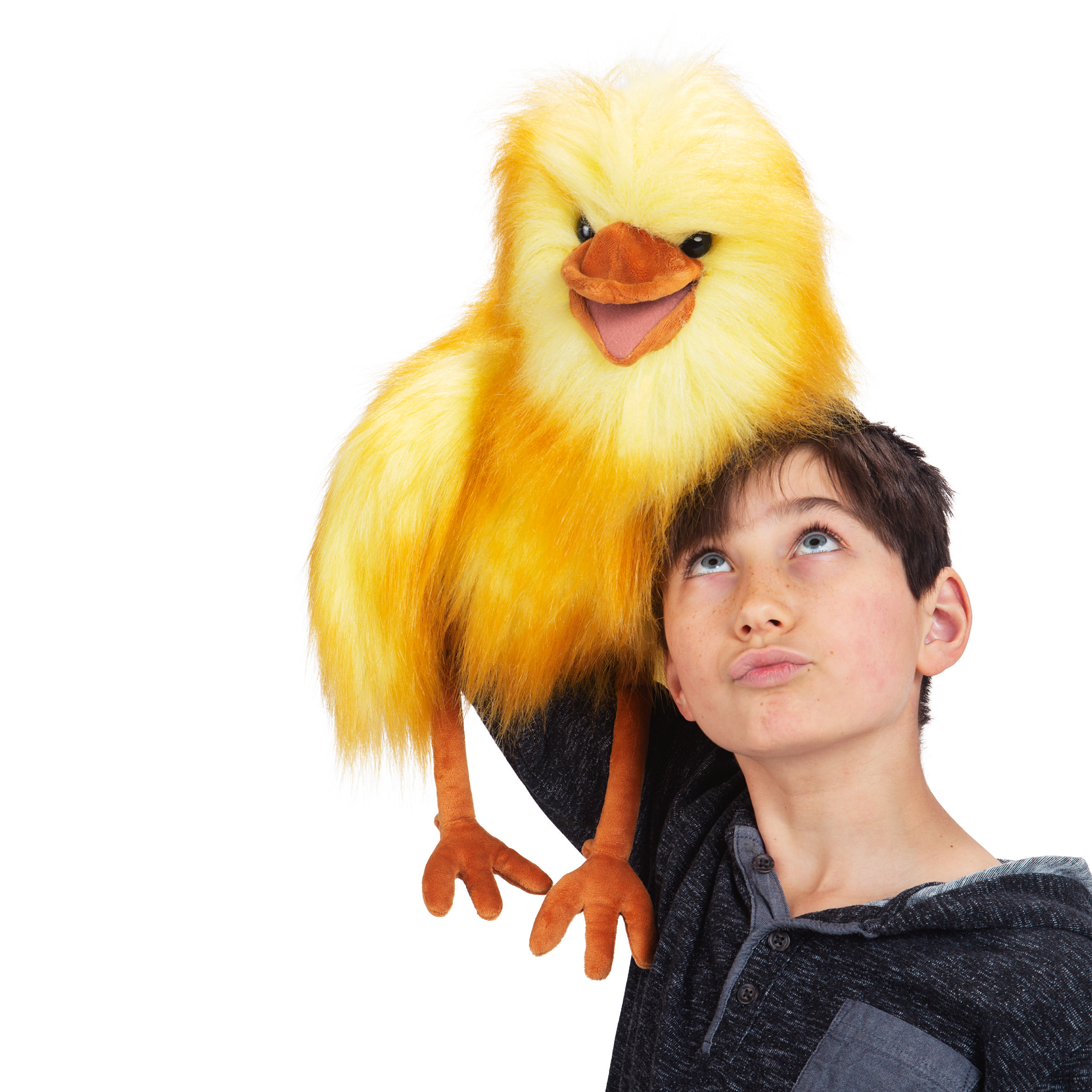 Folkmanis hand puppet yellow bird with open beak sitting on a boy's shoulder as he looks up at the puppet