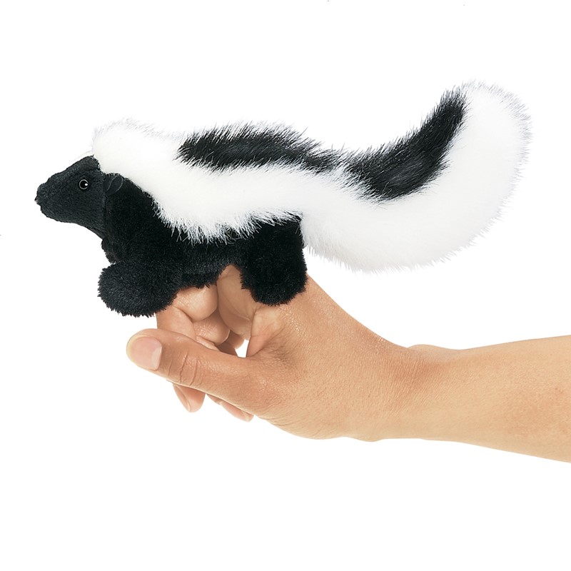 Folkmanis mini skunk finger puppet in black and white on an index finger, side view with bushy tail