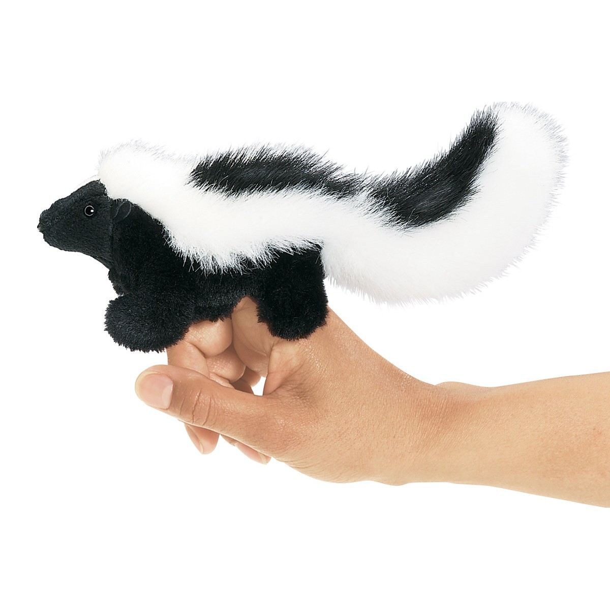 Folkmanis mini skunk finger puppet in black and white on an index finger, side view with bushy tail