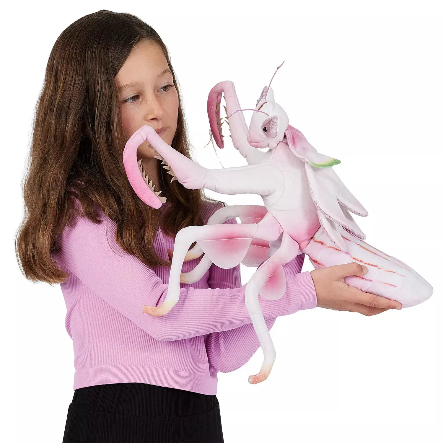 Girl holding a Folkmanis orchid mantis hand puppet in pink and white with detailed wings and forelegs against a white background