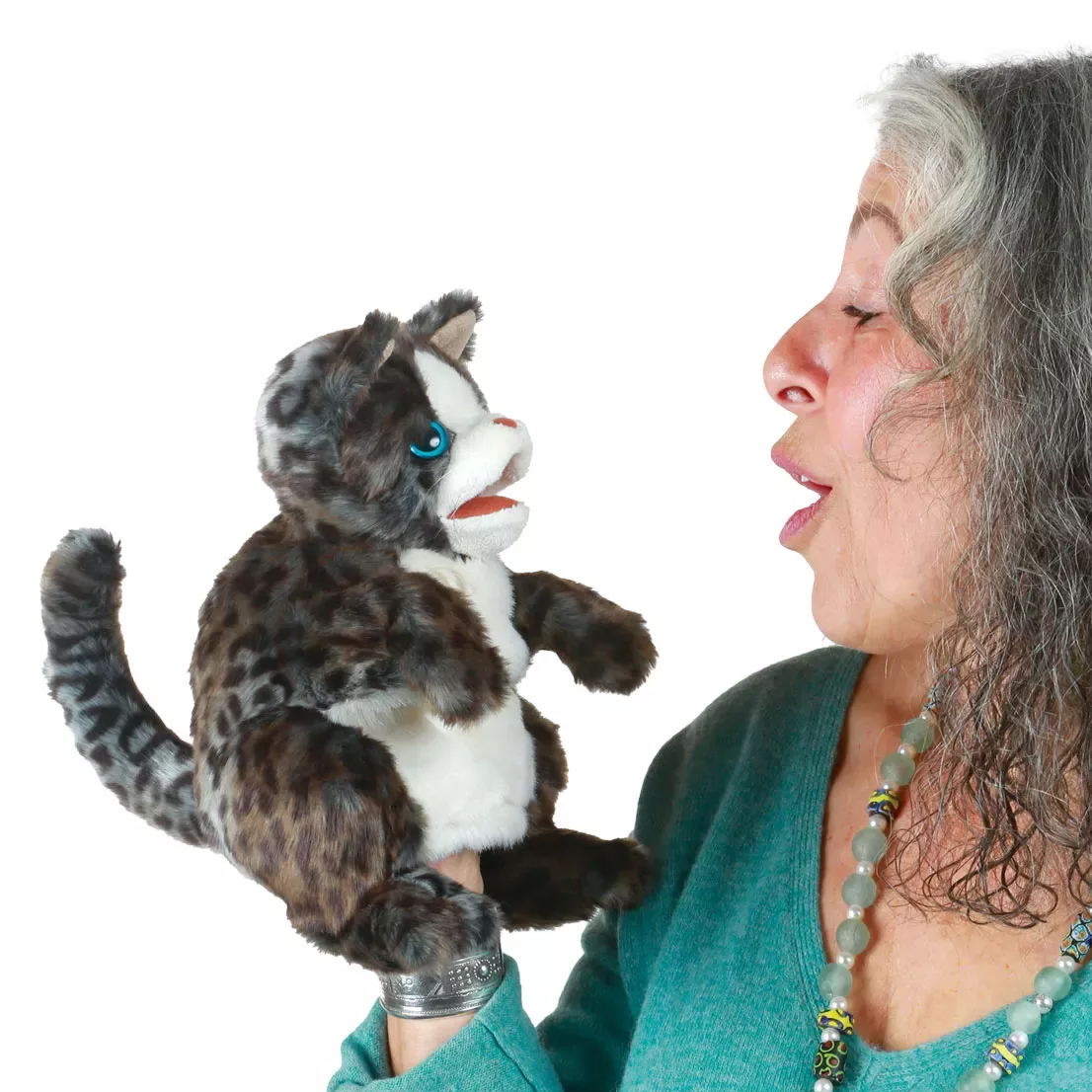 Folkmanis wildcat kitten hand puppet with dark spotted fur and blue eyes, worn on the hand of a woman