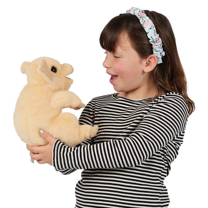 Girl holding a cream-coloured Folkmanis piggy hand puppet with an open mouth in both hands, laughing