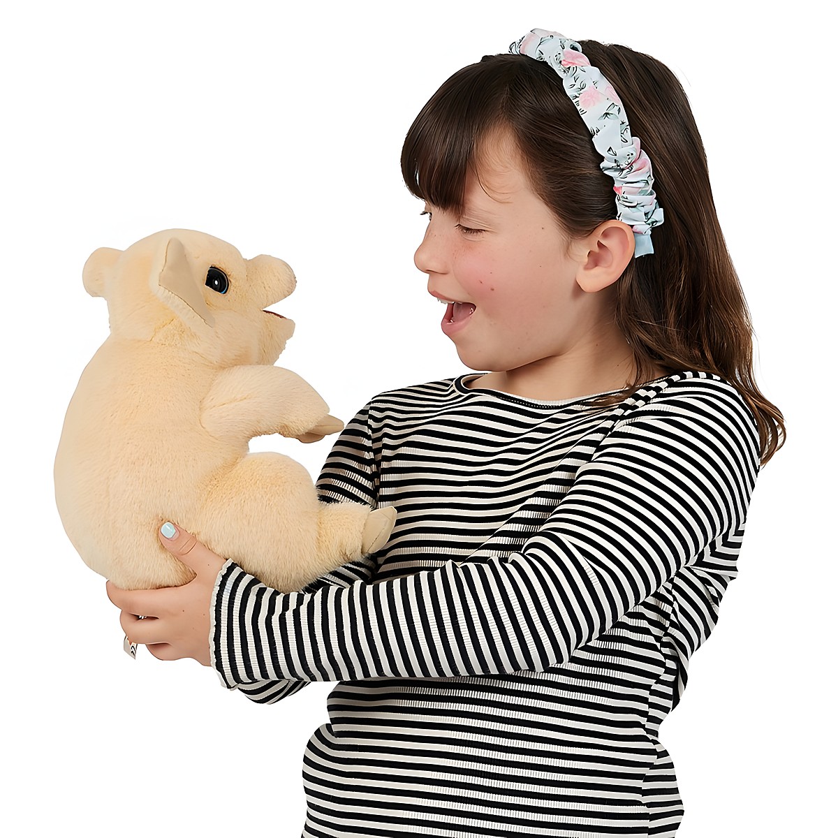 Girl holding a cream-coloured Folkmanis piggy hand puppet with an open mouth in both hands, laughing