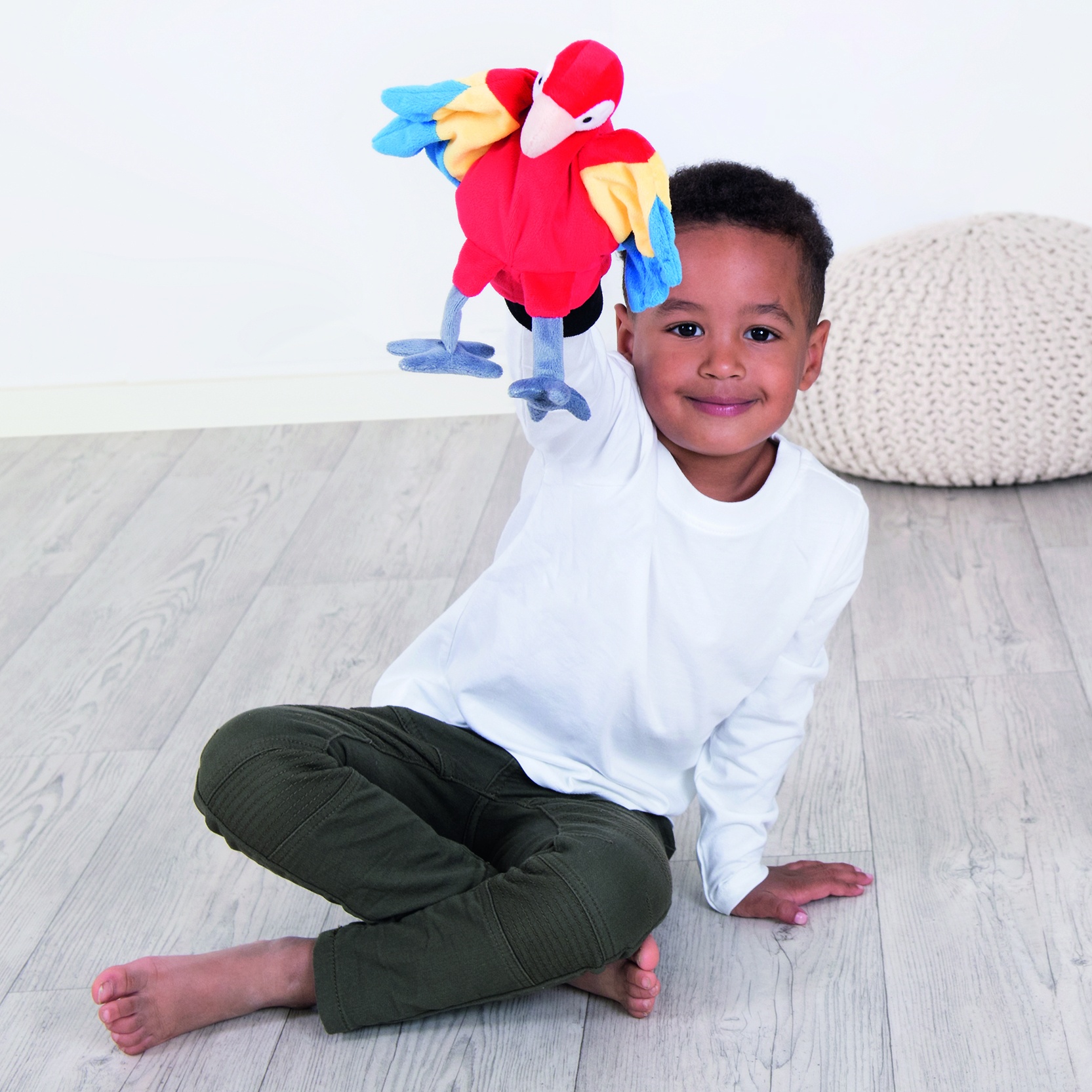 Boy holding the Beleduc hand puppet parrot raised in his hand, usage example