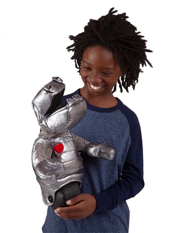 Child smiling while holding the Folkmanis robot hand puppet made of shiny silver fabric with a red heart on its chest
