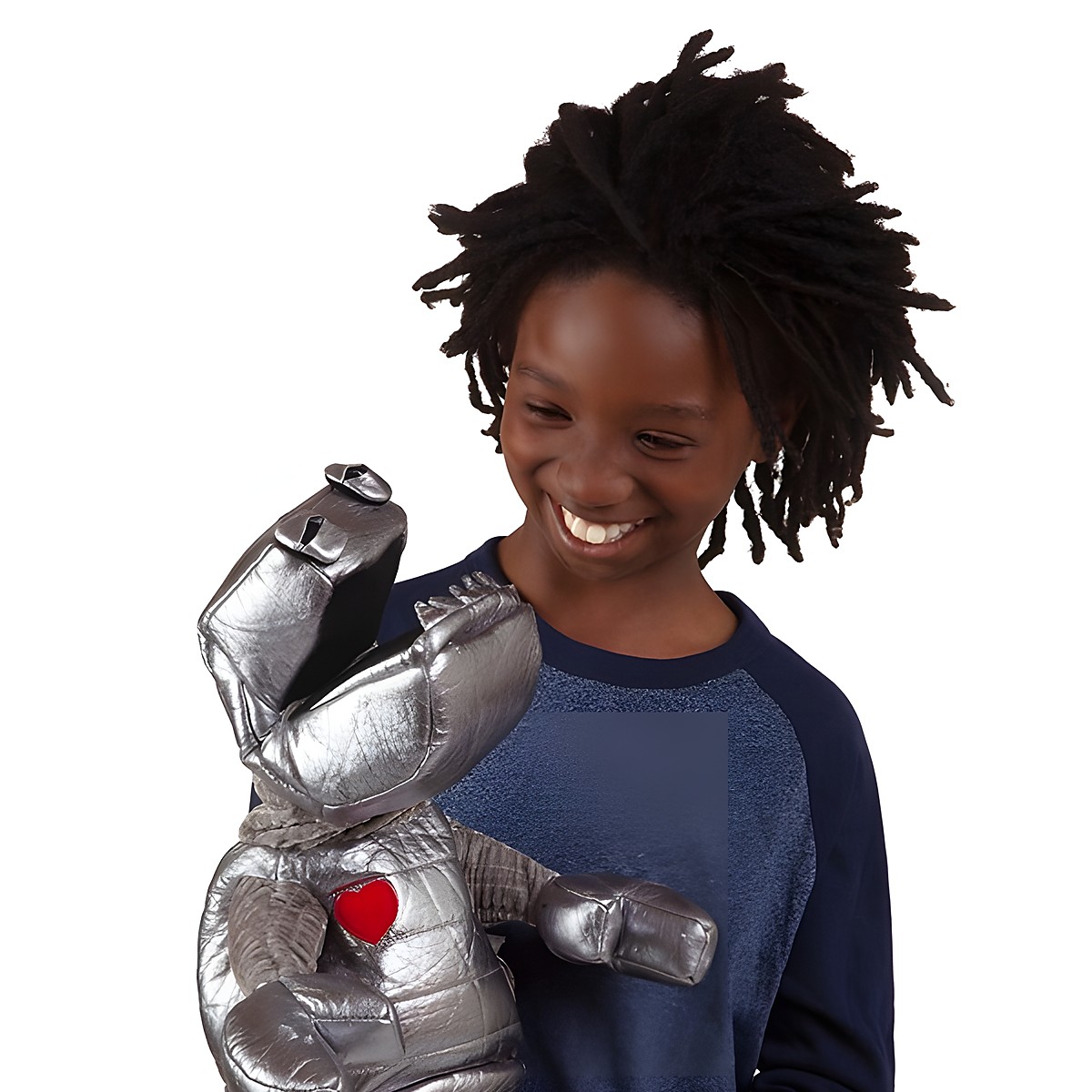 Child smiling while holding the Folkmanis robot hand puppet made of shiny silver fabric with a red heart on its chest