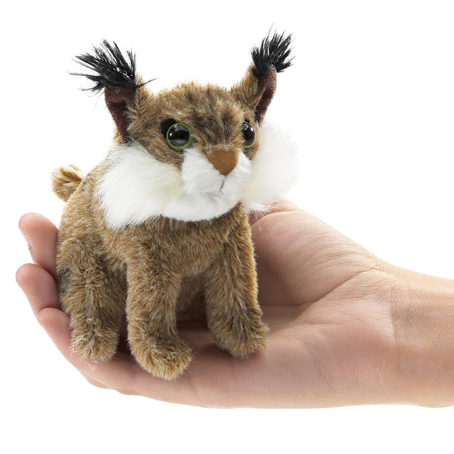 Folkmanis mini bobcat finger puppet with spotted fur, black tufted ears and white cheek ruff, resting on a palm