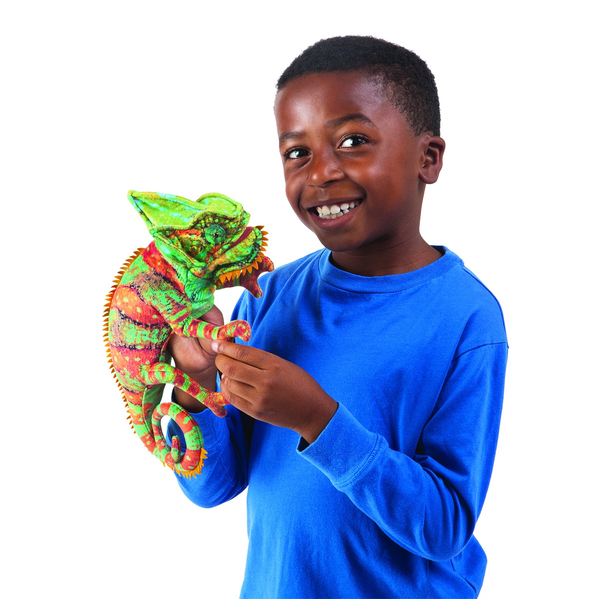 Boy in a blue jumper holding the Folkmanis small chameleon hand puppet in green and red with a curled tail in both hands