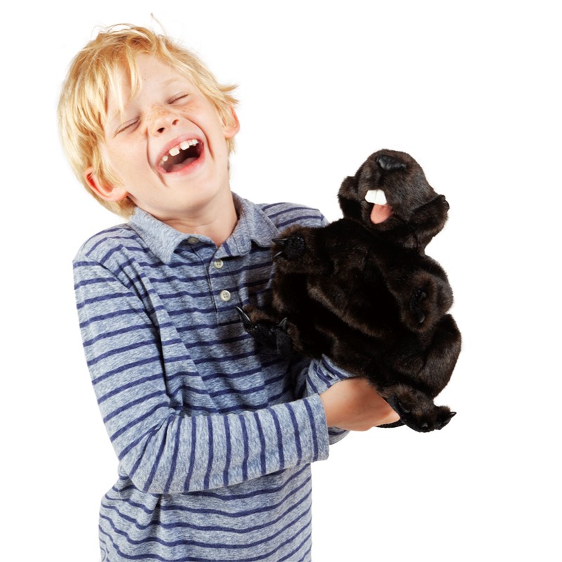 Laughing boy holding the dark brown Folkmanis beaver hand puppet with open mouth in his hands