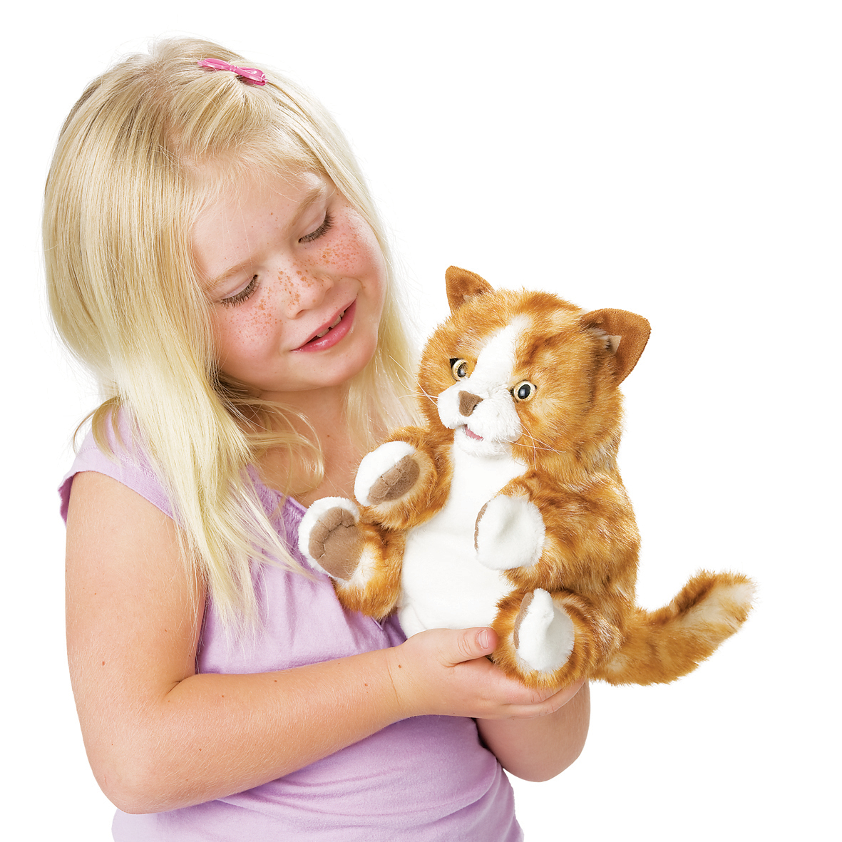 Girl holding the Folkmanis orange tabby kitten hand puppet with white chest and paws, side view.