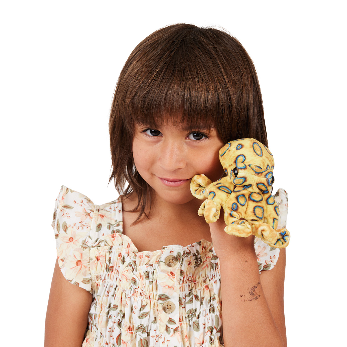 Girl holding a Folkmanis mini blue-ringed octopus finger puppet in yellow and blue against her cheek