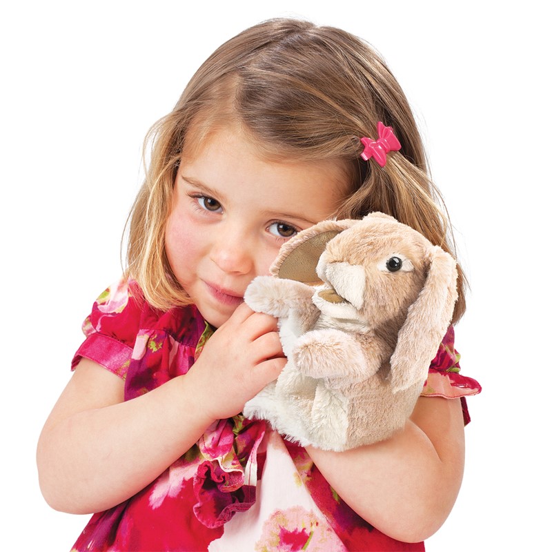 Girl holding a Folkmanis hand puppet little lop-eared rabbit in beige plush with long floppy ears against her cheek